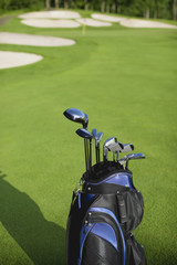Golf bag and clubs against defocused course background