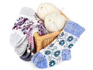 knitted socks, basket and yarn balls with knitting needles