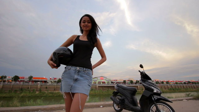 sexy asian girl with mini skirt, helmet, motorcycle in cambodia