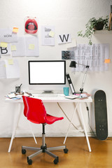 Modern creative workspace with computer and red chair.