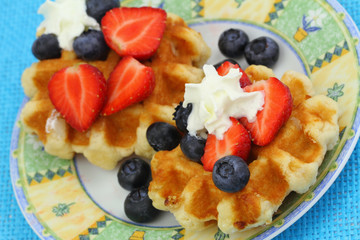 Belgian wafers with strawberries, blueberries and whipped cream