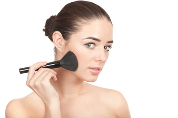 Beauty. Young beautiful woman using cosmetic brush