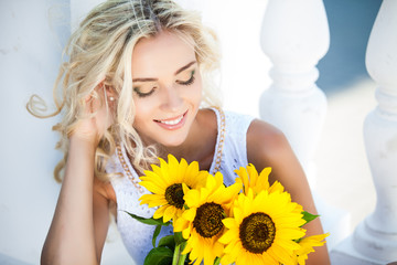 Fototapeta premium portrait of attractive woman with sunflowers in her hand