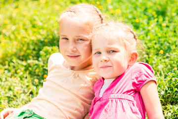 Two smiling little girls on the meadow