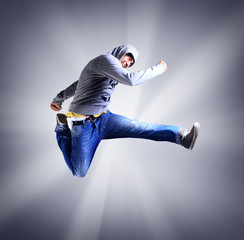 Portrait of an young man jumping in air against light background