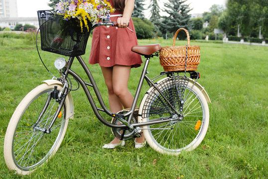 young pretty woman with bicycle and flowers
