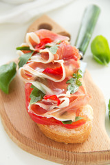 Bruschetta with prosciutto, tomato and basil.