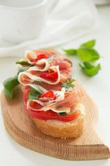 Bruschetta with prosciutto, tomato and basil.