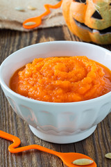 Pumpkin porridge on a background of funny Halloween pumpkin
