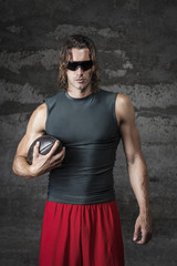 muscle man is wearing sunglasses and holding football ball