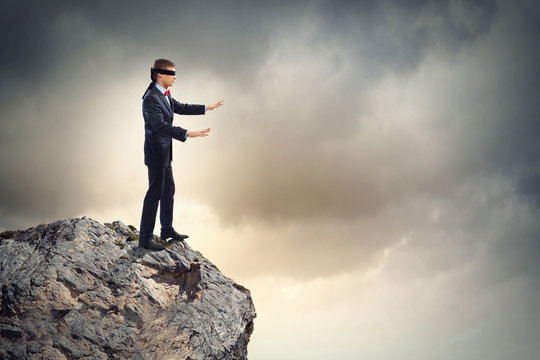 Blindfolded man running off a cliff, conceptual image - Stock Image -  F034/1697 - Science Photo Library