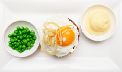 Tenderloin steak with fried egg, potato mash and green pies