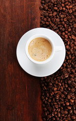 Fototapeta premium Cup of coffee with coffee beans on wooden background