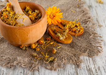 Fresh and dried calendula flowers in mortar on wooden - obrazy, fototapety, plakaty