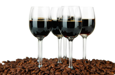 Glasses of liquor and coffee grains, isolated on white