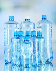 Fototapeta premium Water in different bottles on light background