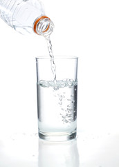 Fresh water pouring in a glass on white background.
