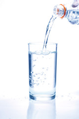 Fresh water pouring in a glass on white background.