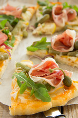 Pizza with arugula and prosciutto.