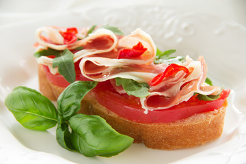 Bruschetta with prosciutto, tomato and basil.