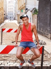 Stylish young man in shorts and cap outdoors