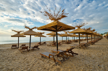 beach with wooden sunshades in the morning