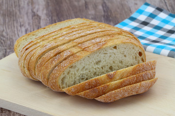Sliced rustic bread on wooden board