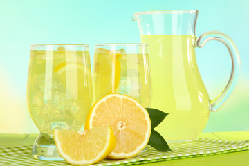 Delicious lemonade on table on light blue background