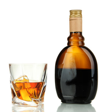 Glass of liquor with bottle, isolated on white