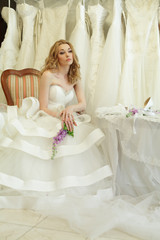 Fototapeta na wymiar Beautiful bride in luxury interior on background of wedding dres
