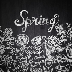 Chalk flowers on chalkboard blackboard. Floral greeting card wit