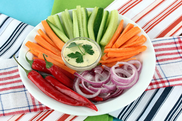 Assorted raw vegetables sticks in plate on napkins close up