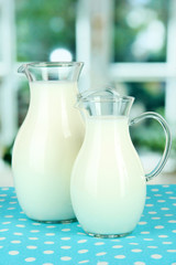 Pitchers of milk on table in room