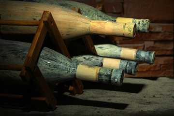 Old bottles of wine in old cellar, on dark  background