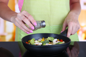 Obraz na płótnie Canvas Hands cooking vegetable ragout in pan in kitchen