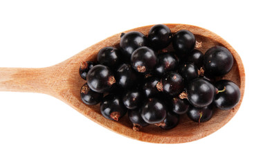 Black currant in wooden spoon isolated on white
