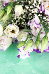 Bouquet of eustoma flowers on color wooden background