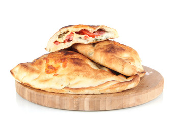 Pizza calzones on wooden board isolated on white