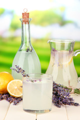 Lavender lemonade in bottle and jug, on bright background