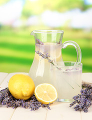 Naklejka premium Lavender lemonade in glass jug, on bright background