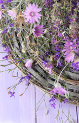 Wild flowers, on wicker mat, on color wooden background