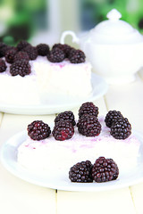 Cheesecake with fresh berries on white plate on wooden table