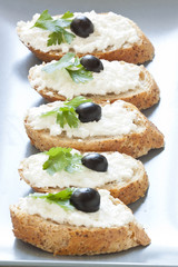 Crostini with cottage cheese, parsley and olive