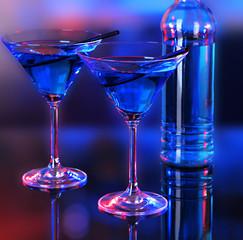Glasses of cocktails on bright background