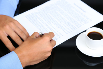 Businessman writing on document in office close-up