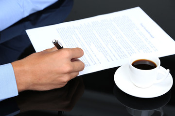 Fototapeta premium Businessman writing on document in office close-up