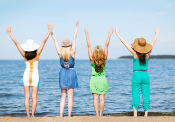 girls looking at the sea with hands up