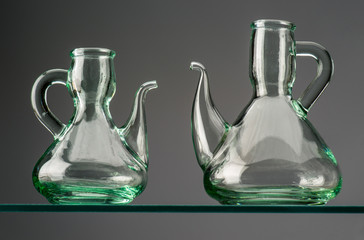 two empty rustic crystal oilcans on crystal shelf