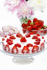 Strawberry cake on rustic wooden table in lush summer garden