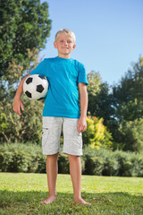 Young blonde boy holding football